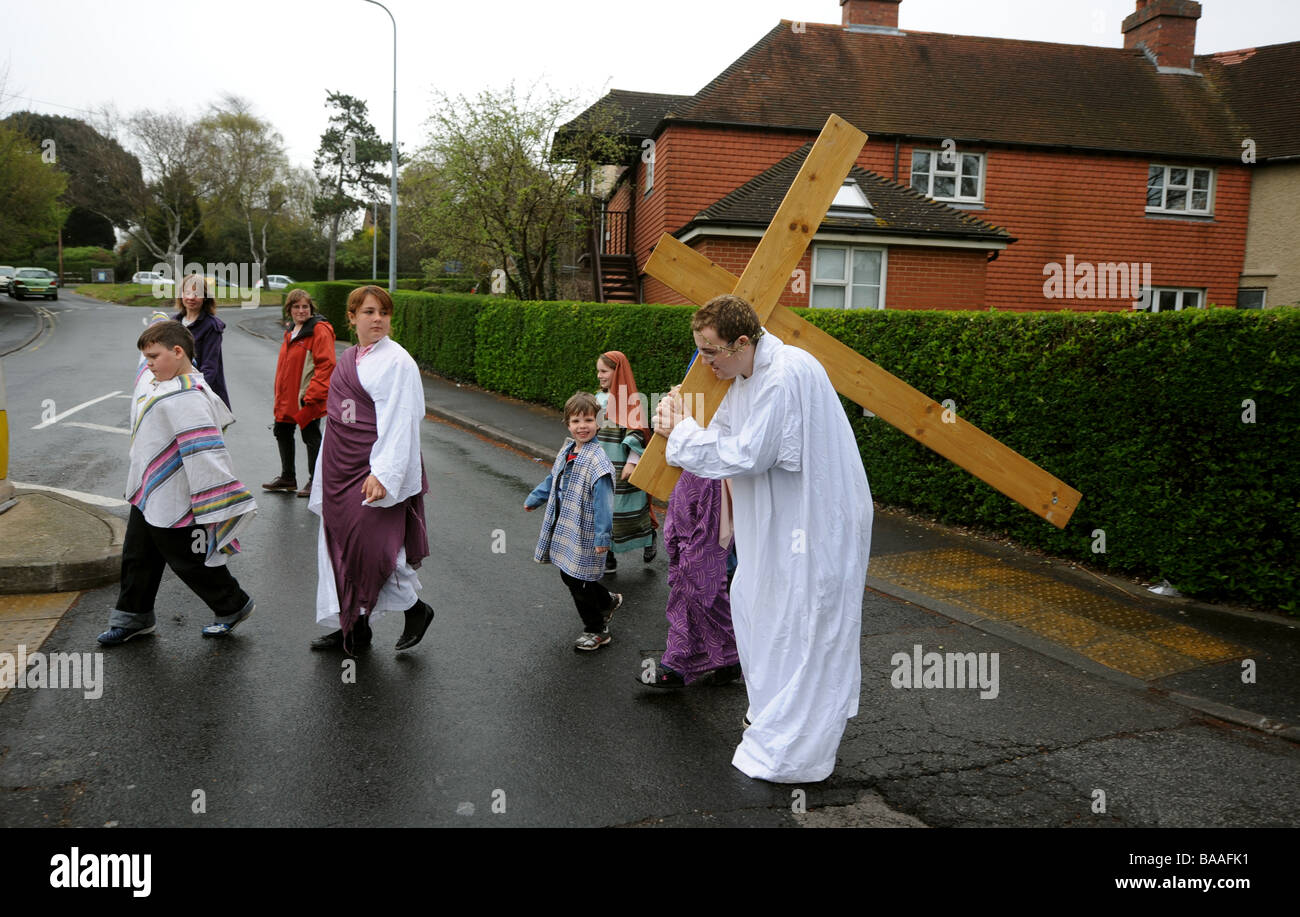 Un adolescente porta una croce sulle spalle come egli gioca la parte di Gesù in una nuova promulgazione della Passione il servizio sul Venerdì Santo Foto Stock