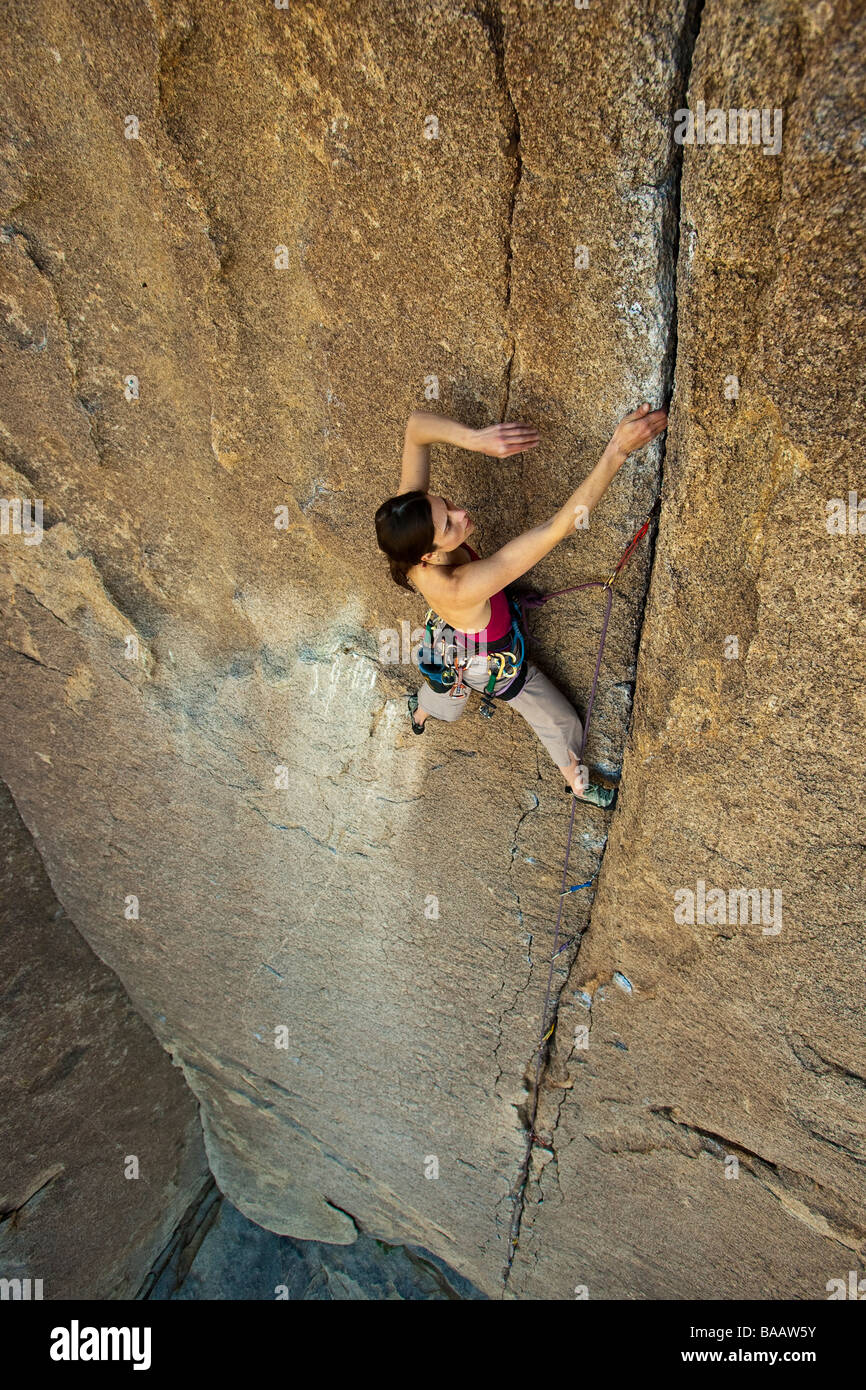Female Rock climber aggrappati alla cima di una scogliera. Foto Stock