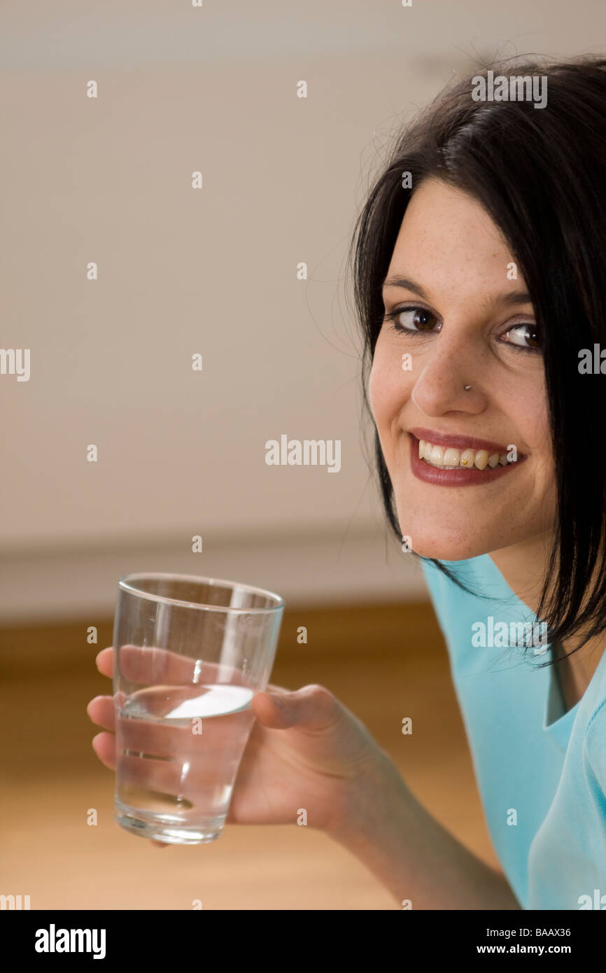 La donna è acqua potabile da un vetro - Frau trinkt Wasser aus einem Glas Foto Stock