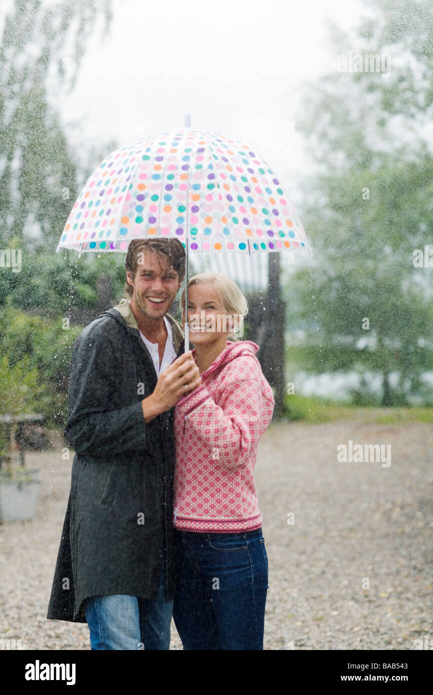 Un uomo e una donna in piedi sotto un ombrello, Svezia. Foto Stock