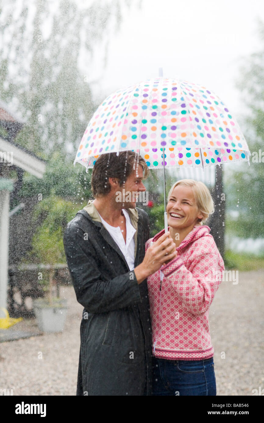 Un uomo e una donna in piedi sotto un ombrello, Svezia. Foto Stock