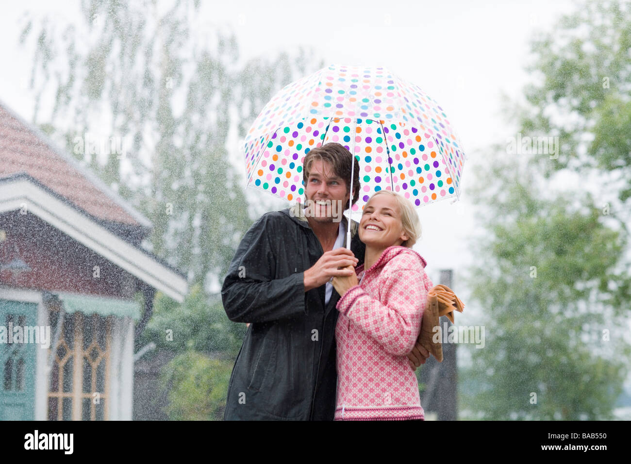 Un uomo e una donna in piedi sotto un ombrello, Svezia. Foto Stock