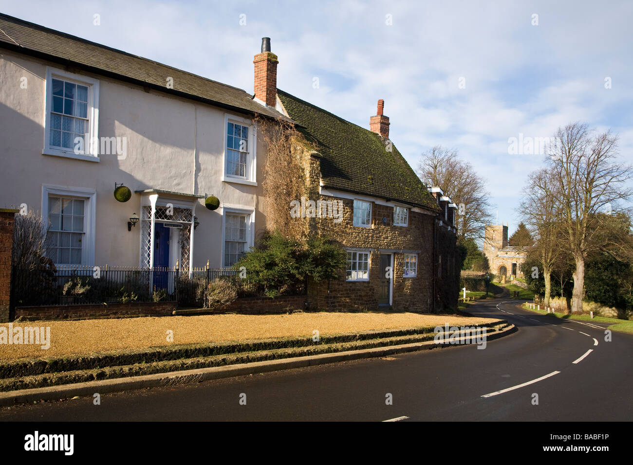 Strada principale con cottage e villaggio chiesa Scaldwell Northamptonshire England Regno Unito GB Foto Stock