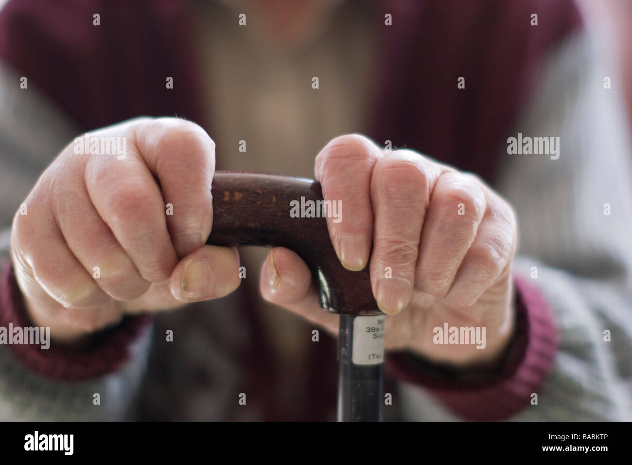 Uomo anziano oap vecchiaia titolare di pensione o di rendita delle mani che impugnano un bastone a casa Foto Stock