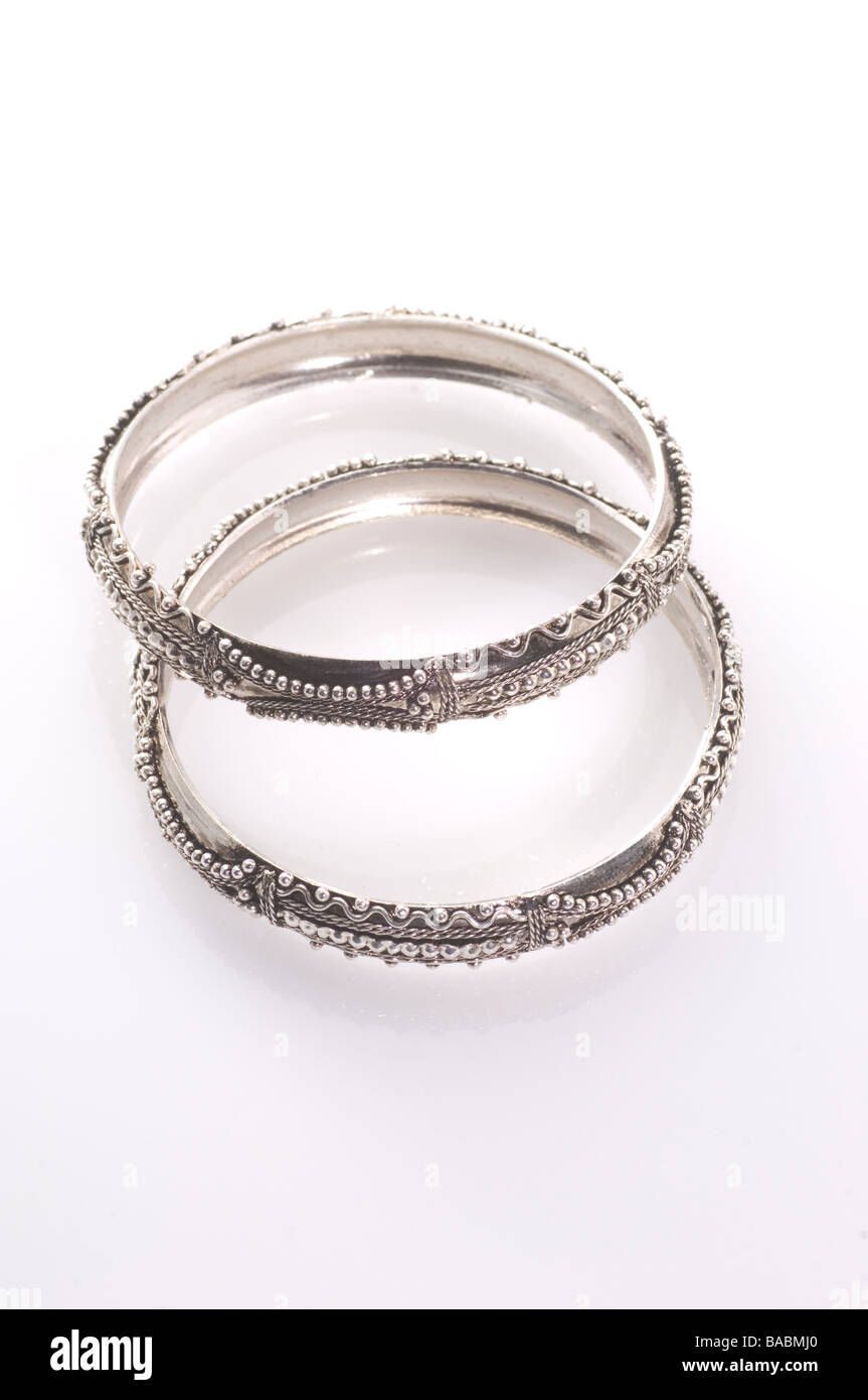 Due bracciali in argento intaglio su sfondo bianco Foto Stock