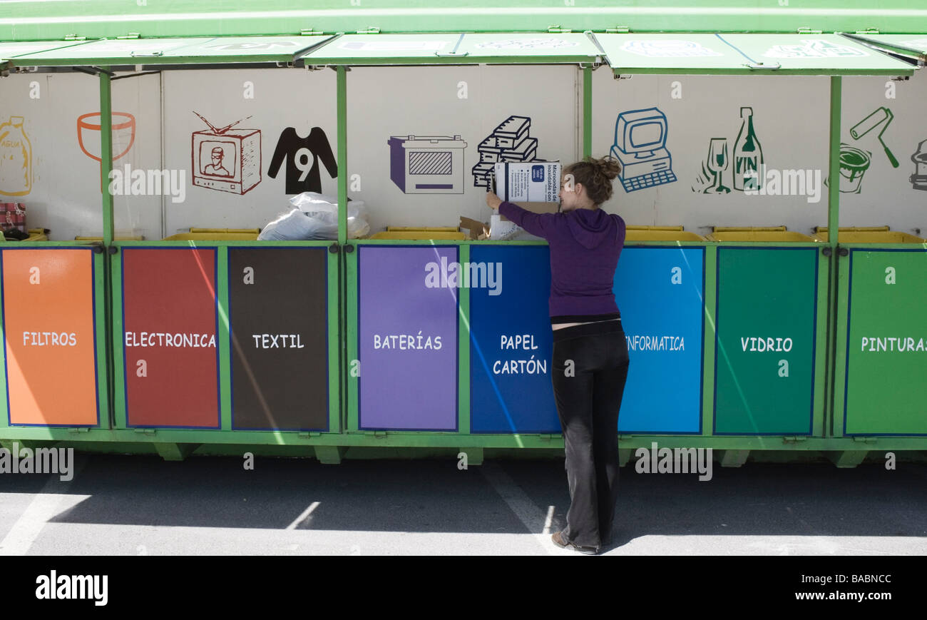 Giovane donna il riciclaggio di scatole di cartone al mobile unità di riciclaggio in Torremolinos Malaga Spagna Foto Stock