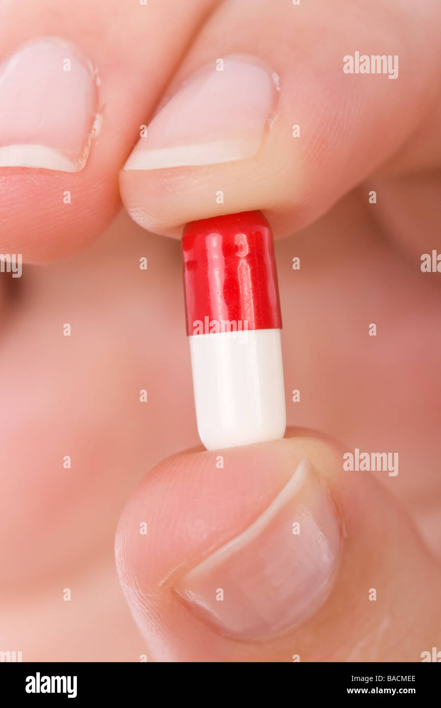 Mano che regge una capsula o una pillola close up Foto Stock