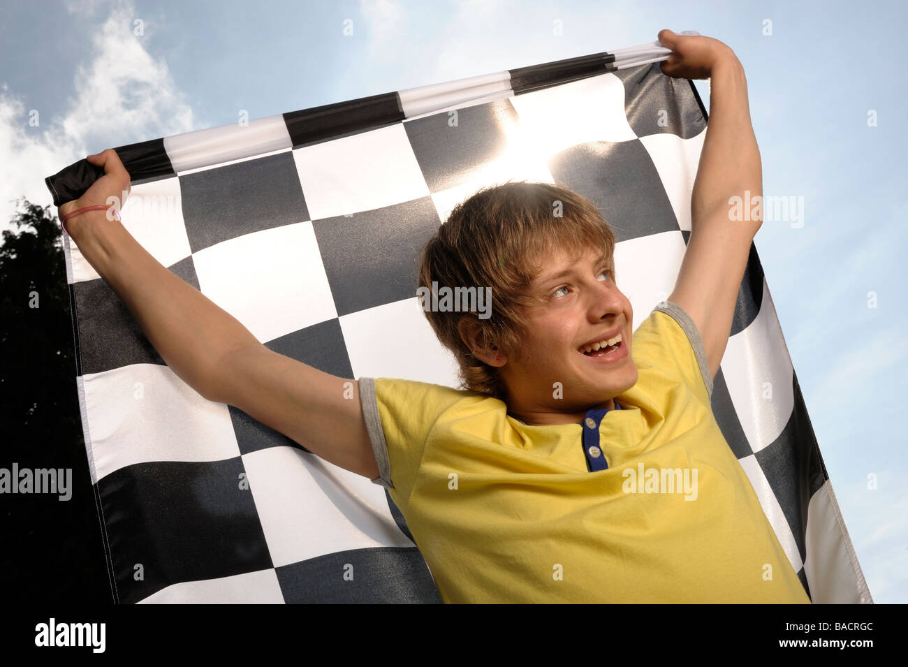 Ragazzo sventola una bandiera a scacchi Foto Stock
