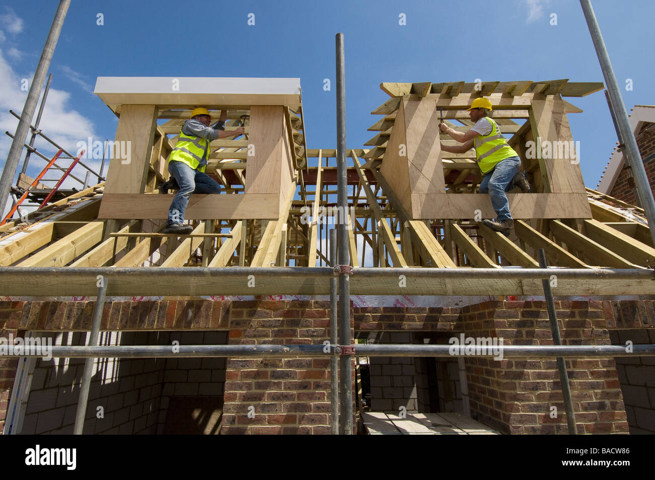 Carpentieri di lavoro sul tetto di una casa nuova. Foto Stock