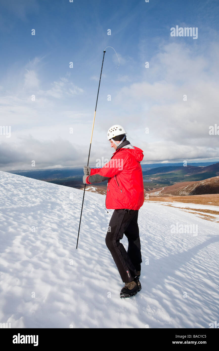 Un membro della Scottish Servizio Valanghe dimostra come utilizzare una sonda a valanga su Cairngorm Foto Stock