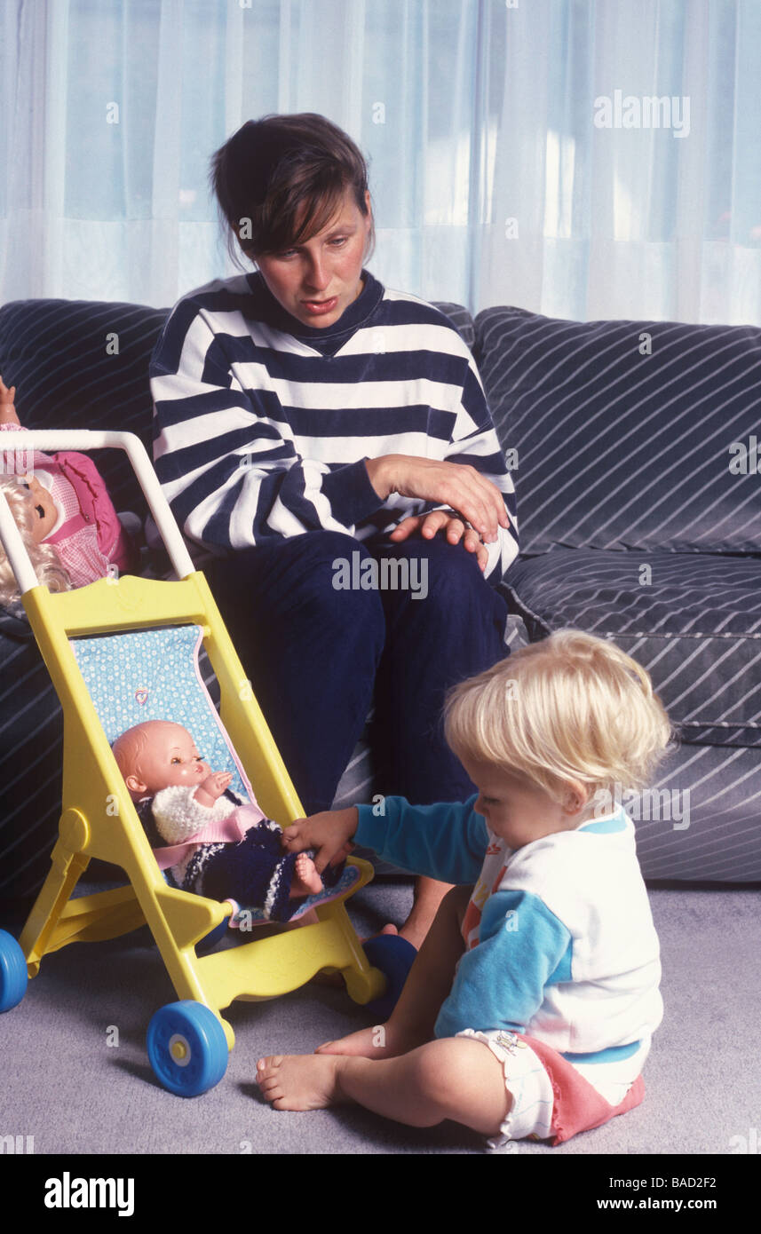 Bambino che gioca con la bambola come bambinaia guarda su Foto Stock