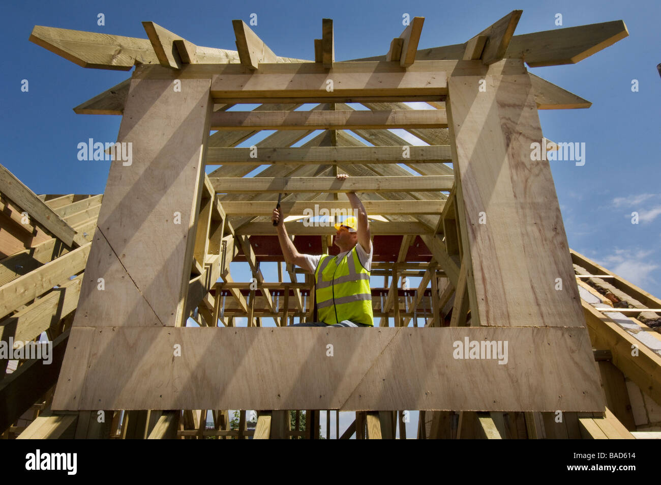 Un copritetti al lavoro su una nuova casa con finestre dormer Foto Stock