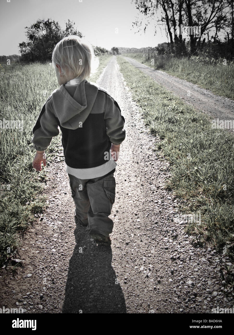 Bambino a piedi lungo una strada di ghiaia Foto Stock