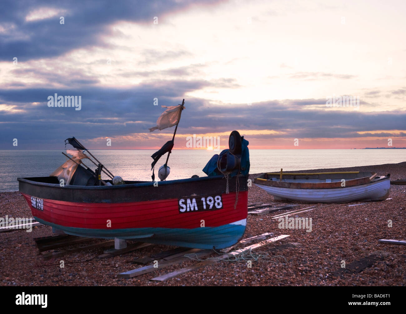 Barche di pescatori sulla spiaggia di Hove, Sussex, al tramonto Foto Stock
