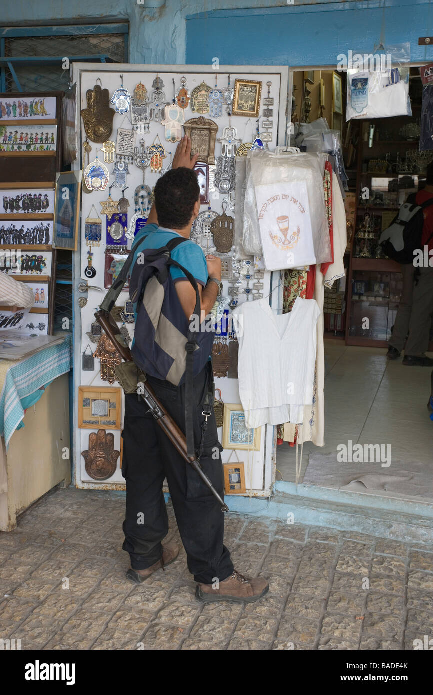 Israele, Distretto Settentrionale, la Galilea Safed, soldato in congedo prima di un religioso souvenir shop con il suo fucile Foto Stock