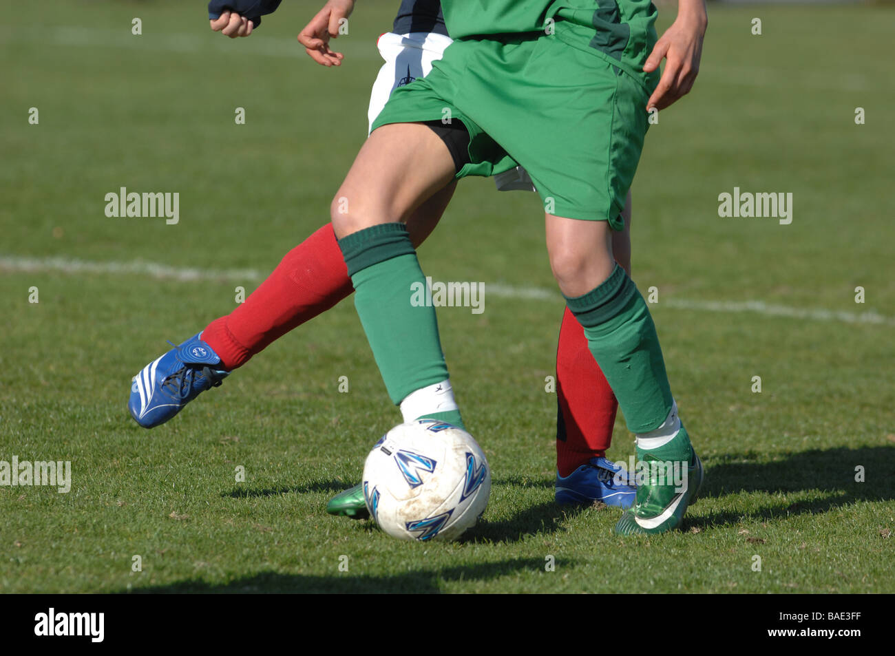 Dettaglio di due calciatori gambe e piedi con calcio. Foto Stock