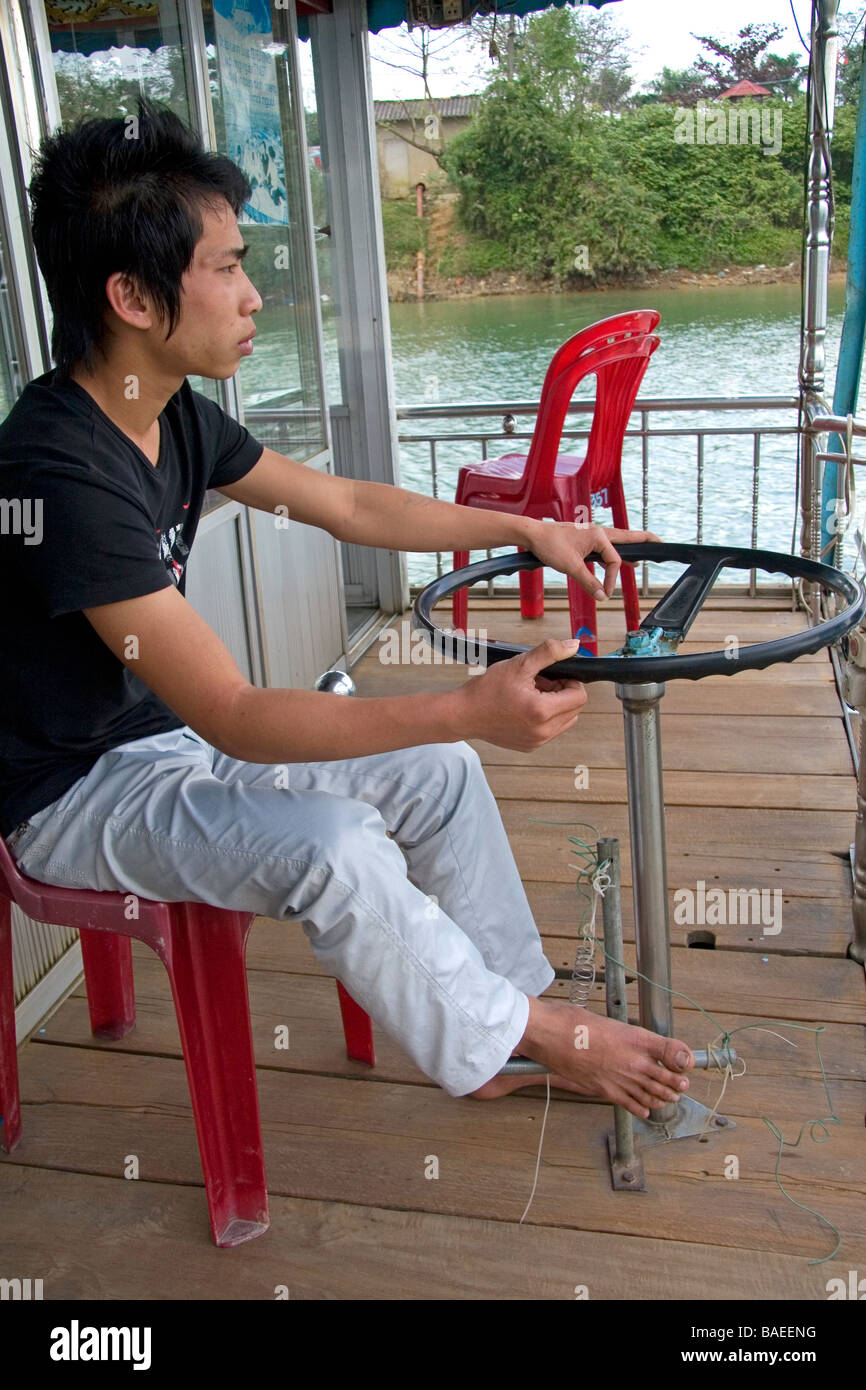Il vietnamita uomo alla guida di un drago barca sul Fiume Perfume di Hue Vietnam Foto Stock