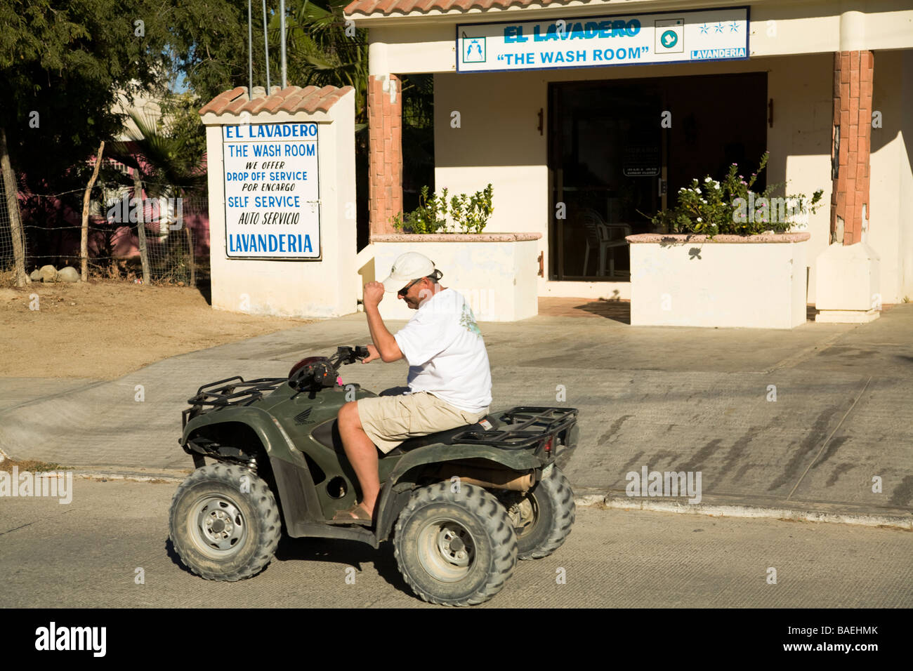 Messico Los Barriles pensionati American uomo alla guida di un ATV su strada in città Foto Stock