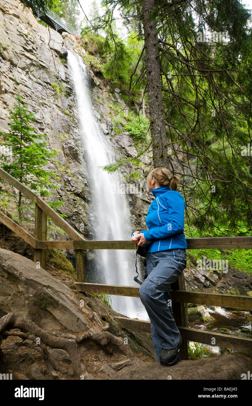 Giovane donna che guarda le cascate di Plodda, vicino a Tomich, Highland Region, Scozia, UK Foto Stock