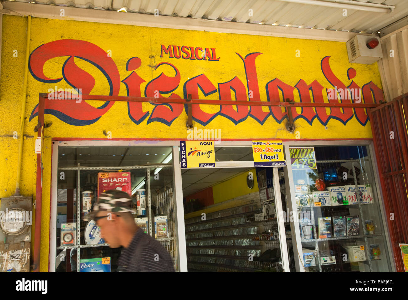 Messico La Paz esterno del negozio vendita cd musicali giovane uomo a piedi ingresso passato sfocato Foto Stock
