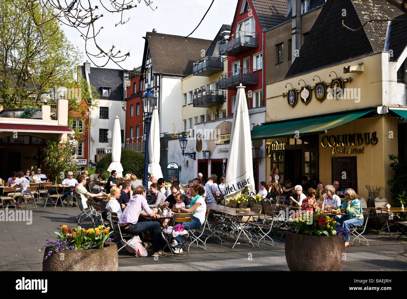 Gente che si diverte nel sole di primavera nei ristoranti del centro storico di Colonia Foto Stock