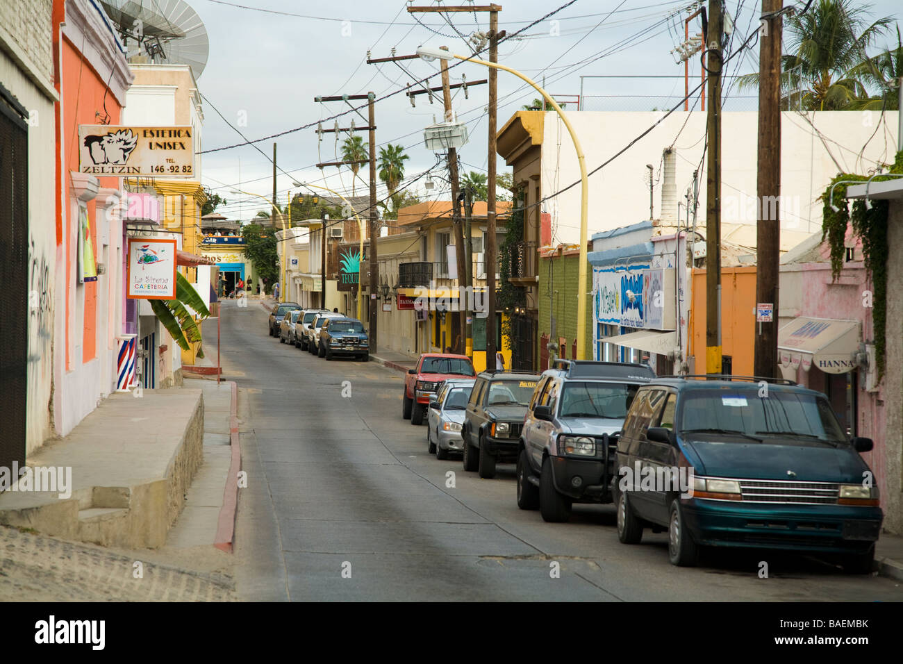 Messico San Jose del Cabo automobili parcheggiate lungo una strada di città in città del Messico segni per aziende e negozi Foto Stock