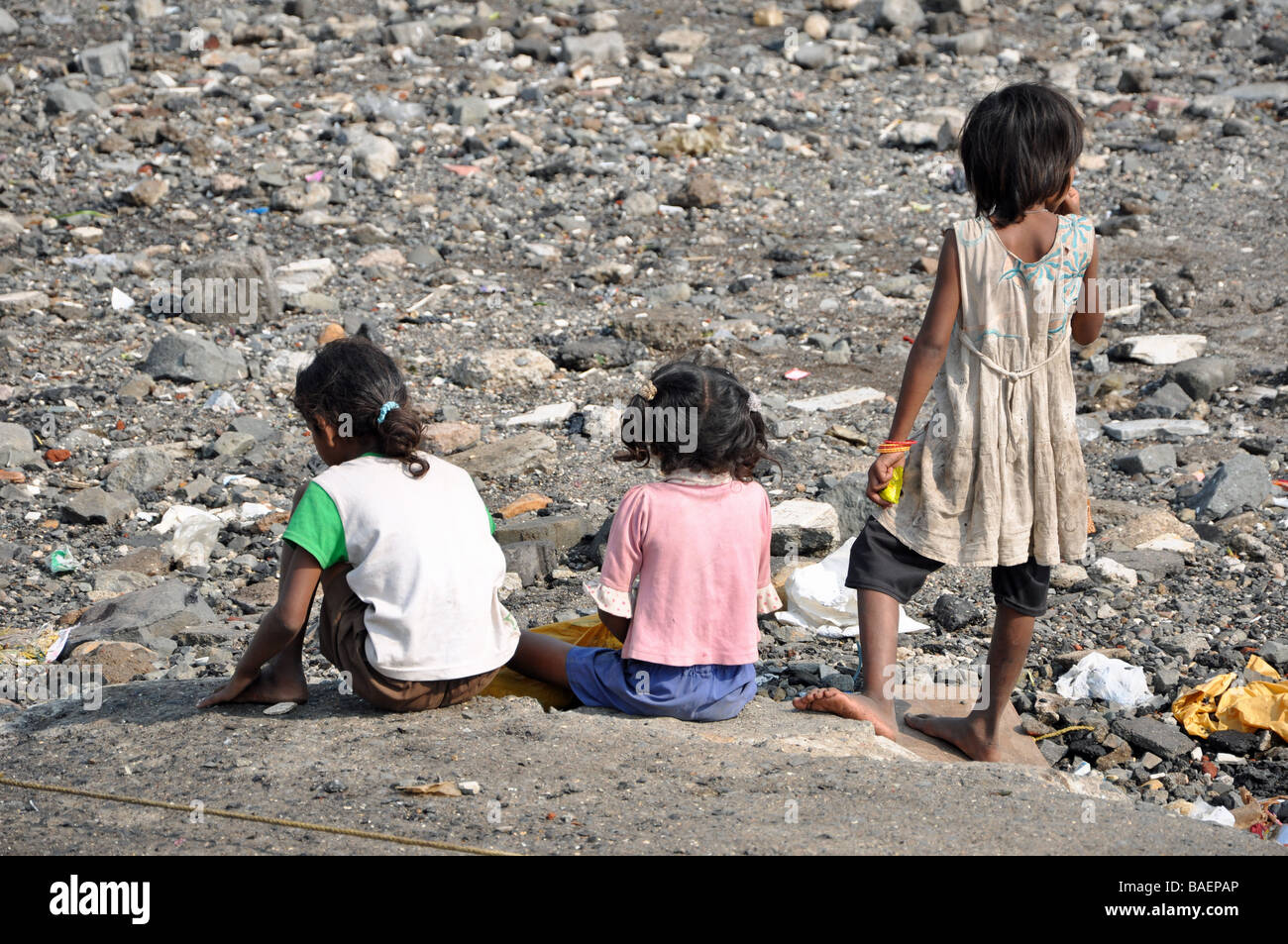 I bambini a guardare le barche dei pescatori che rientrano al mare a sud di Mumbai, India Foto Stock