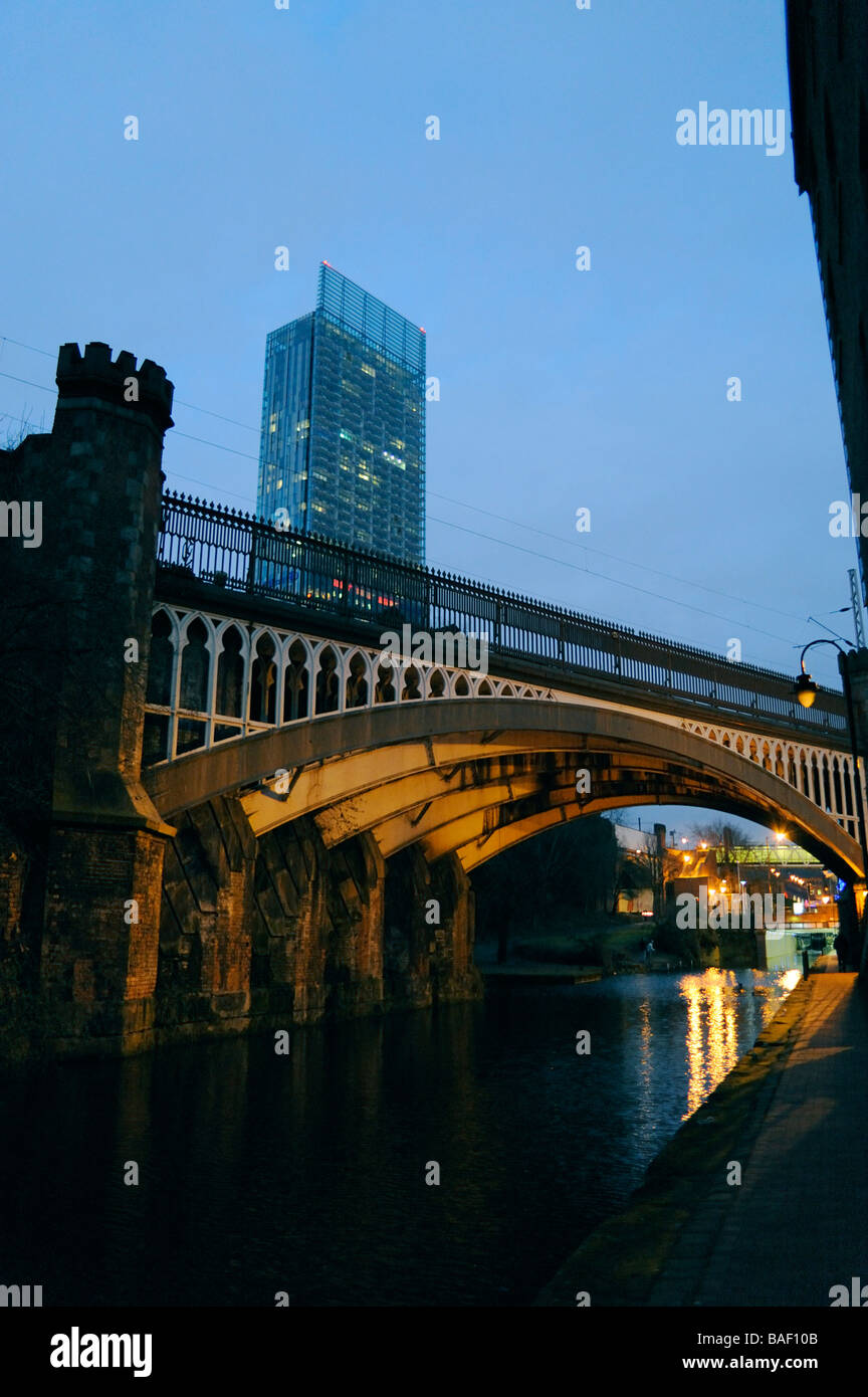 Manchester,Castlefield,industriale vecchio ponte ferroviario su Bridgewater Canal,ultra moderno Hilton hotel Beetham Tower sera Foto Stock