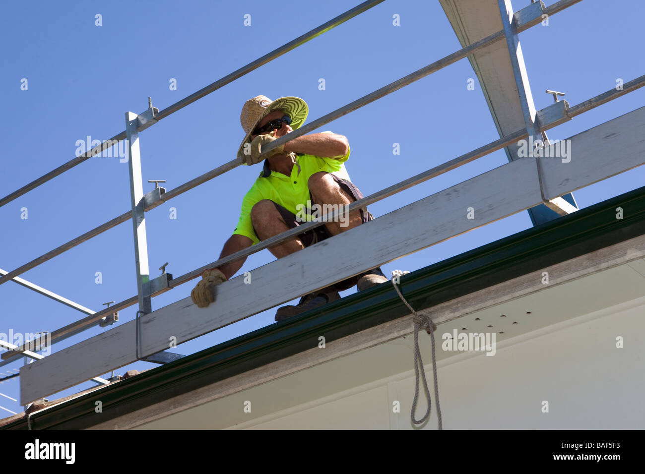 Uomo di erigere di rotaie di sicurezza attorno a terra cotta tetto di tegole, Sydney, Nuovo Galles del Sud, Australia Foto Stock