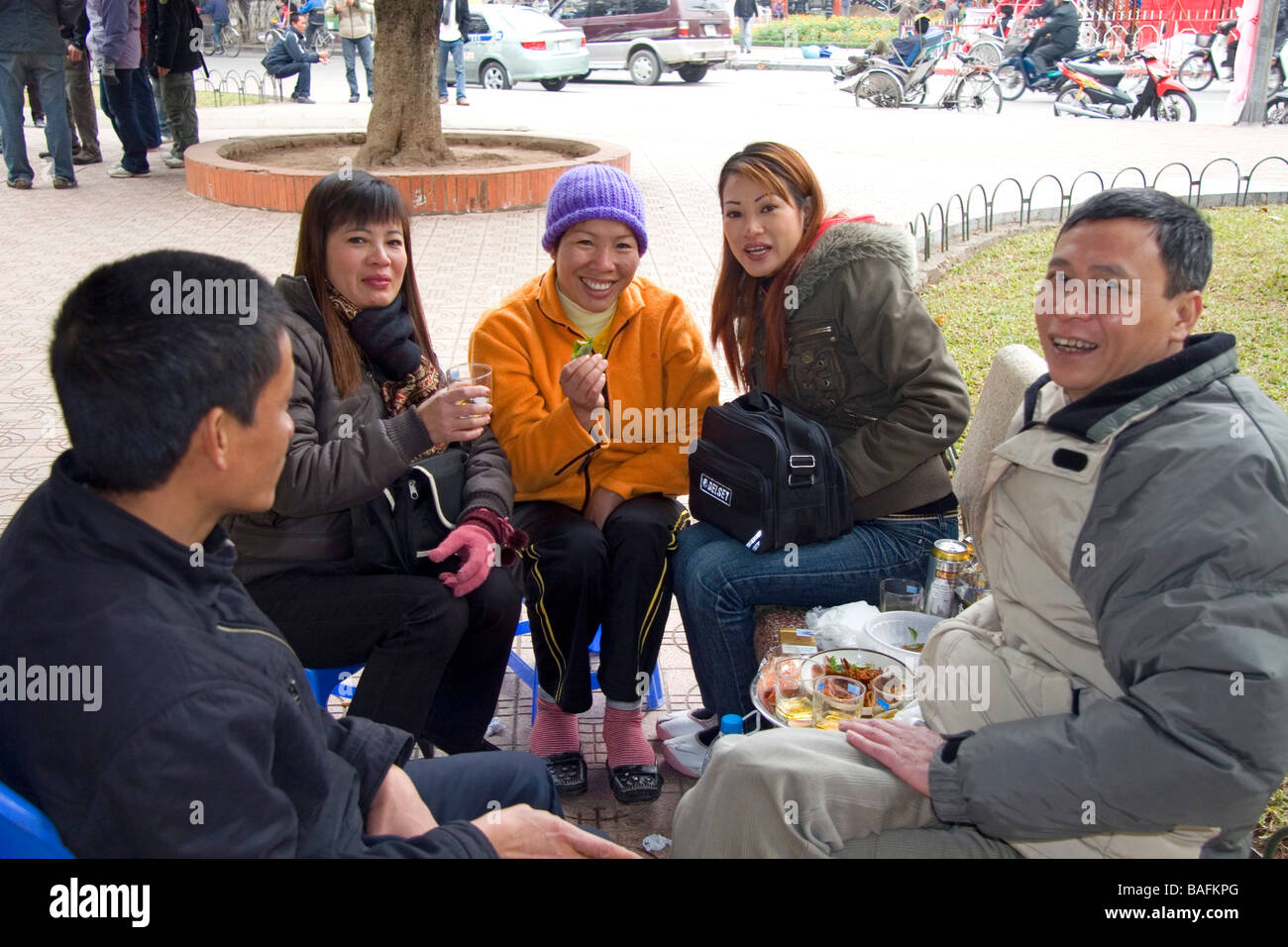 Popolo vietnamita socializzare sulla strada durante il Tet festeggiamenti in Hanoi Vietnam Foto Stock