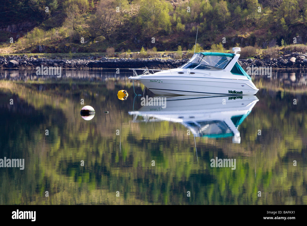 Una barca riflessa nelle acque ancora di Loch Sunart a Strontian Foto Stock