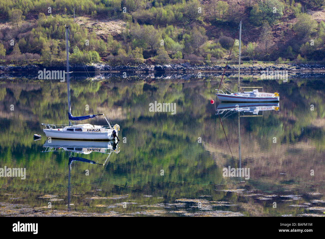 Yatchs riflessa nelle acque ancora di Loch Sunart a Strontian Foto Stock