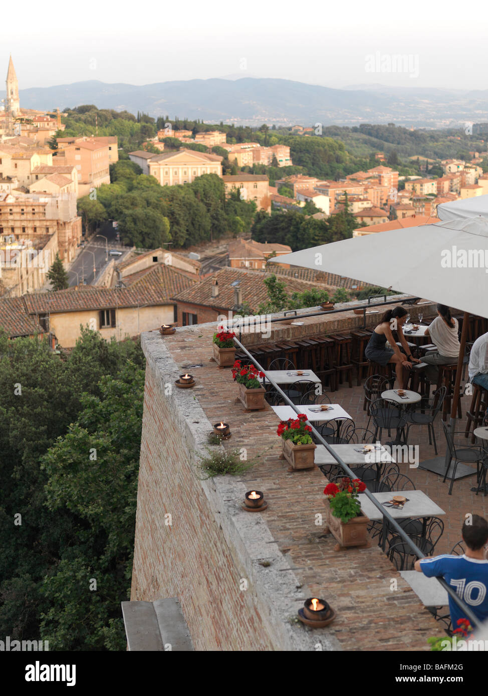 Un bar con una vista impareggiabile di Perugia è riempito con diverse tabelle di coppie. Foto Stock