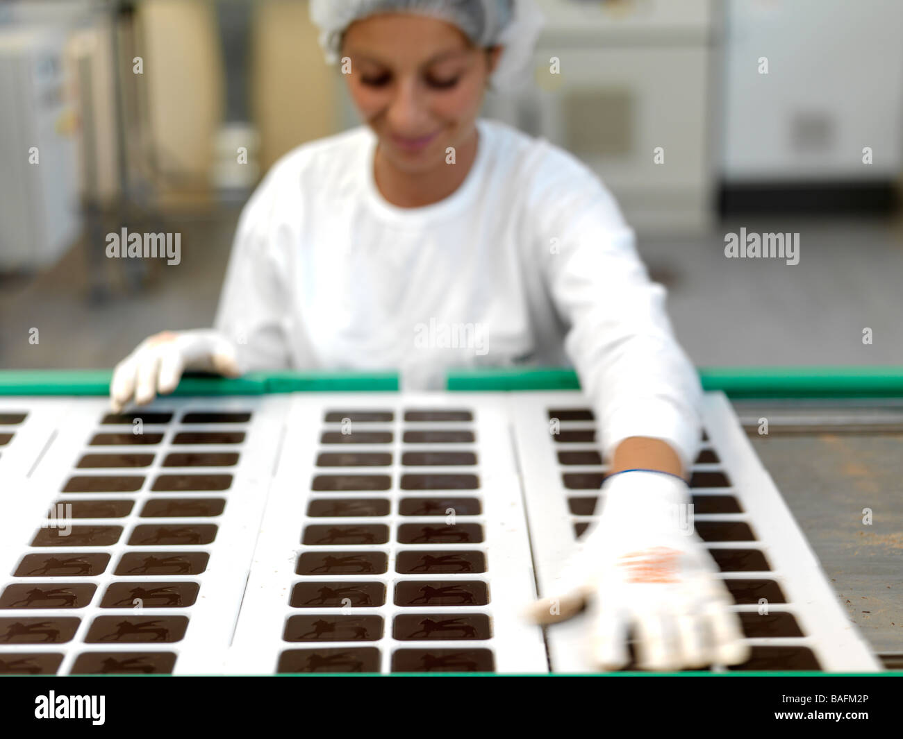 Una donna che lavora in una fabbrica di cioccolato. Foto Stock