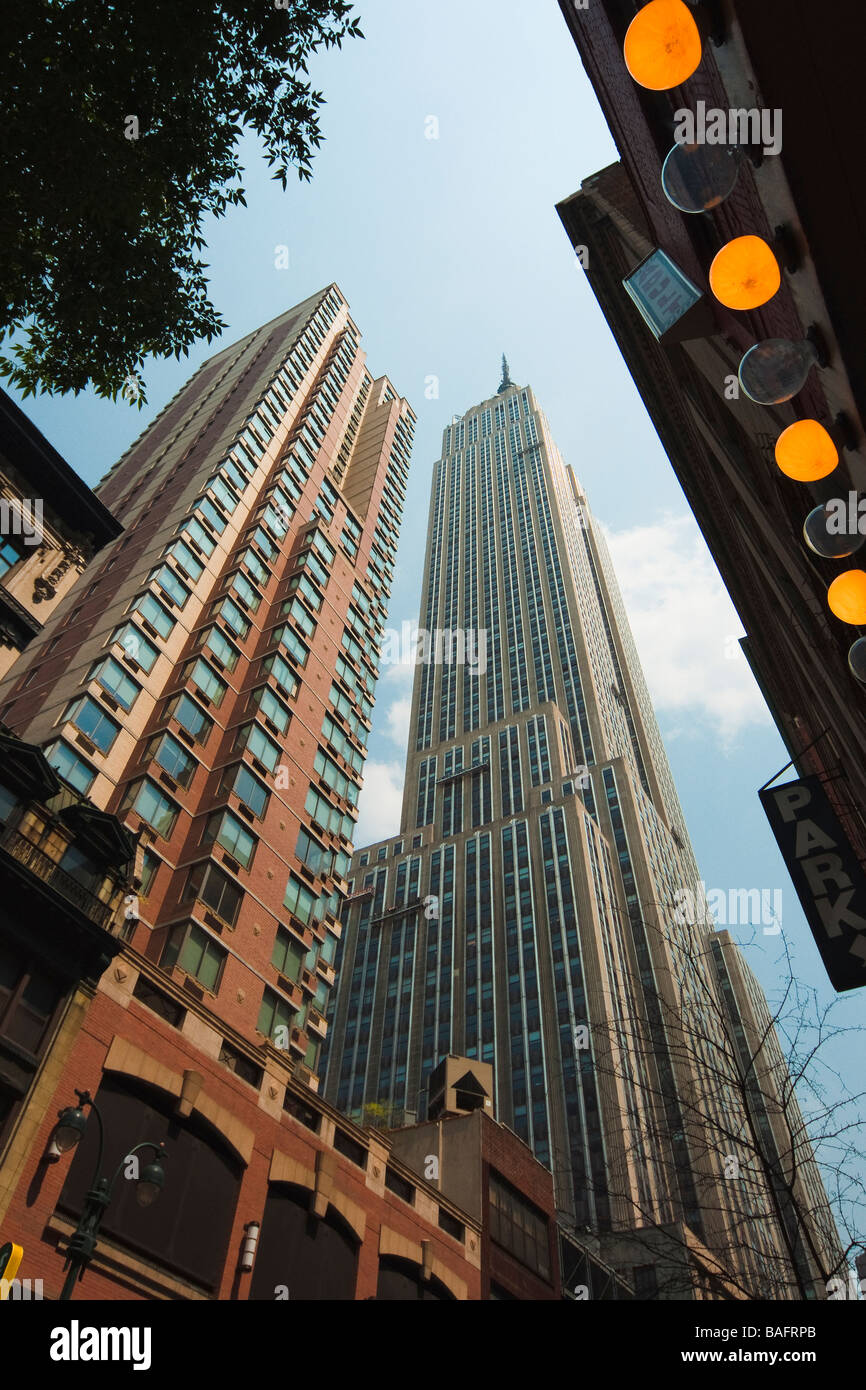 Intrattenimento di NYC, l'Empire State Building dietro le luci di un teatro e un segno pubblicità DVD per adulti. Foto Stock