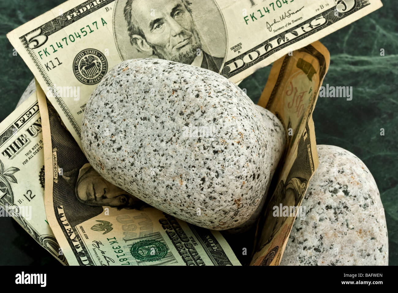 American carta moneta intrecciate in una pila di rocce. Foto Stock