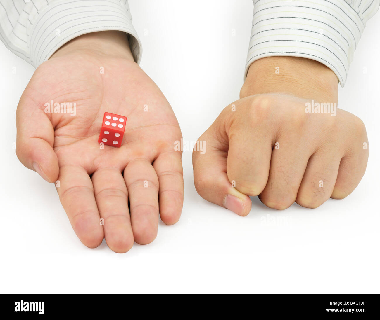 Una mano tenere un dadi rossi,un'altra mano chiuso Foto Stock