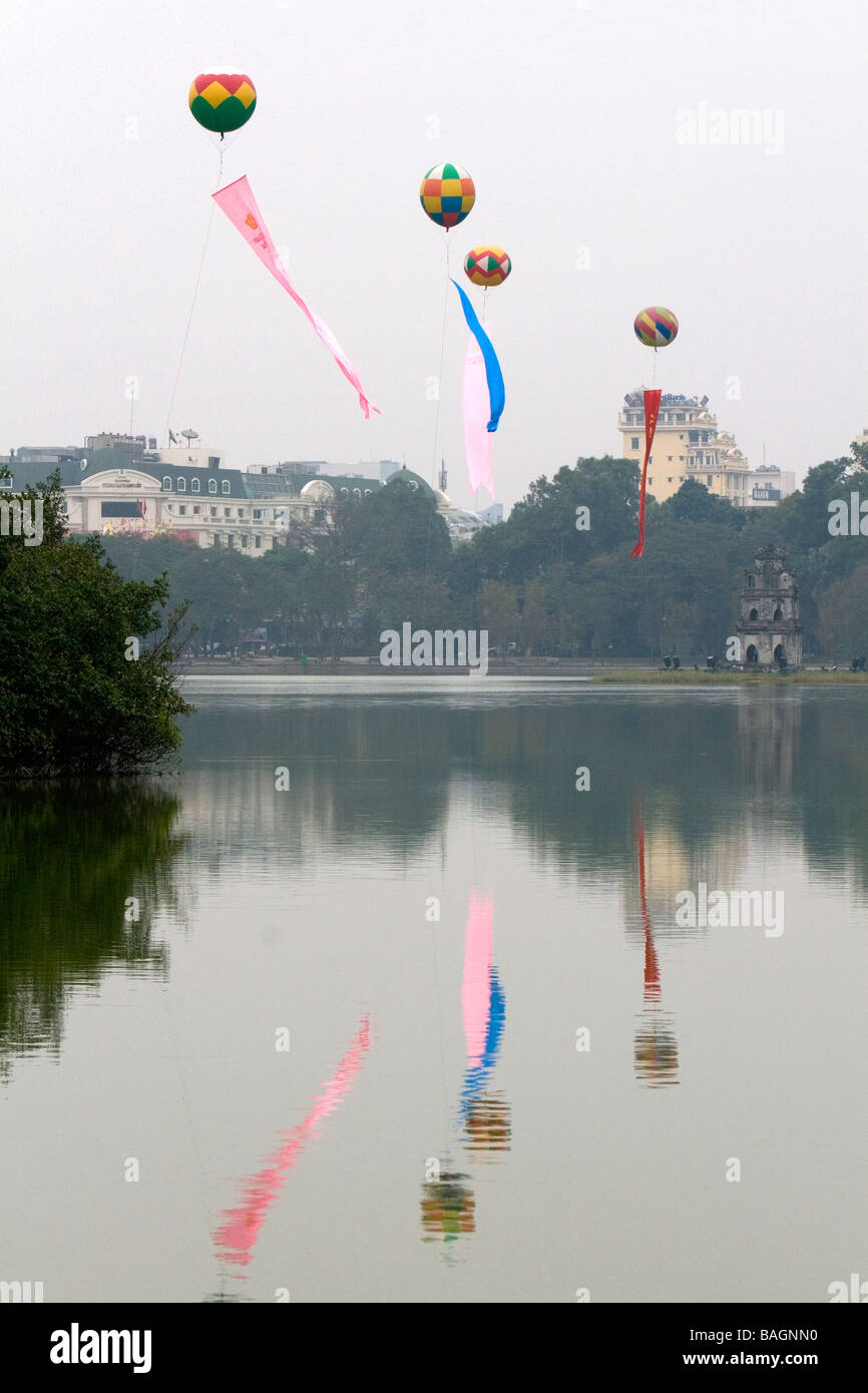 Tet decorazione di mongolfiere grandi galleggiare sopra il Lago Hoan Kiem in Hanoi Vietnam Foto Stock