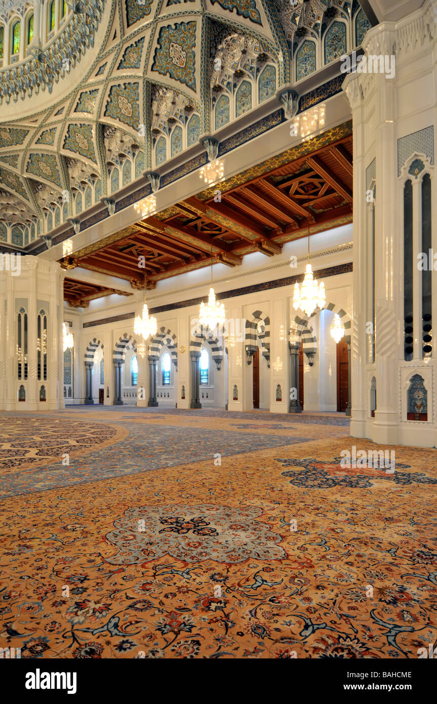 Il Muscat Oman grande moschea interno la preghiera hall grande lampadario appeso al di sotto la cupola ornata visto da direttamente al di sotto Foto Stock