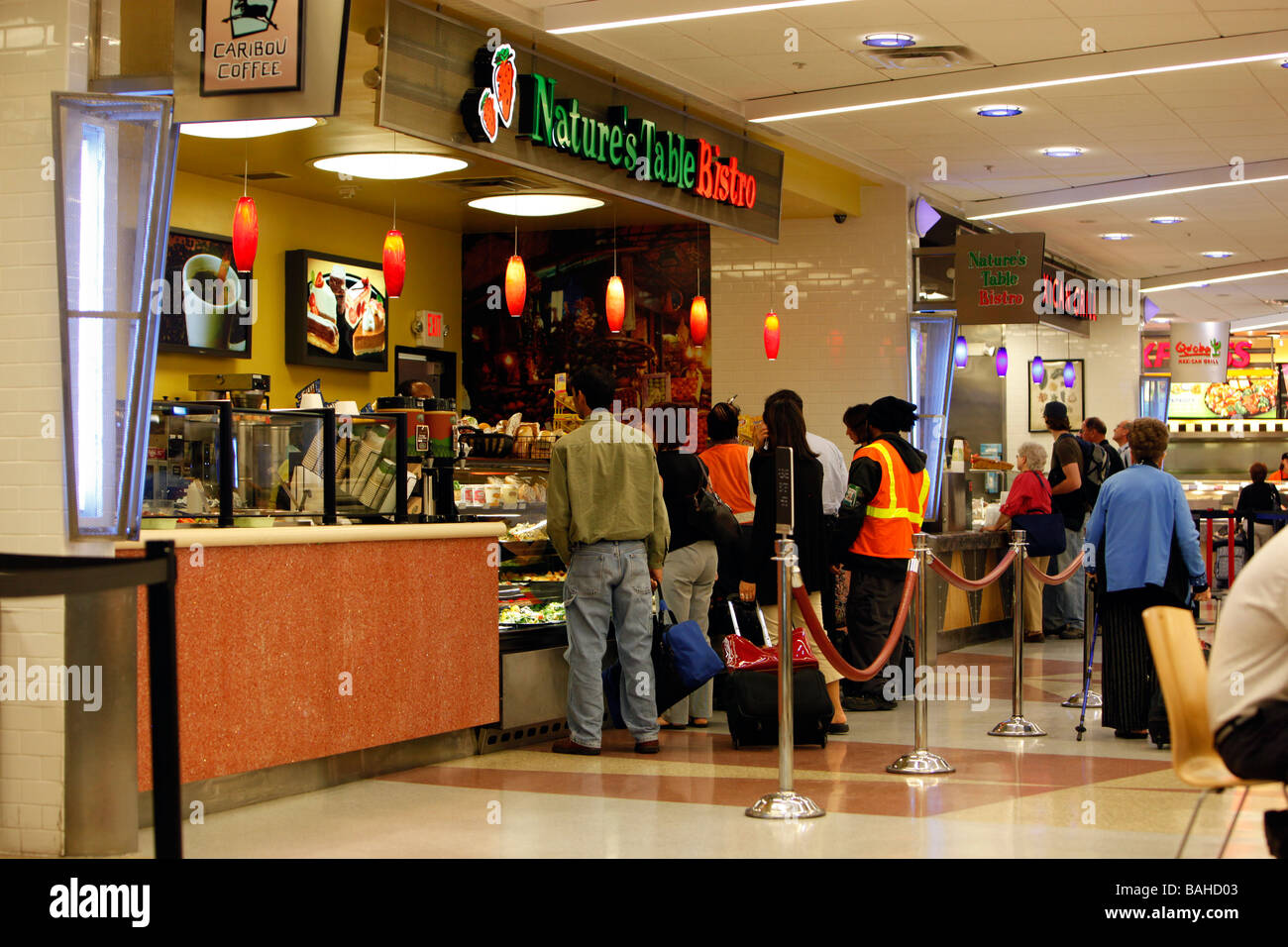 Persone ordinare del cibo in un aeroporto cibo lounge Foto Stock