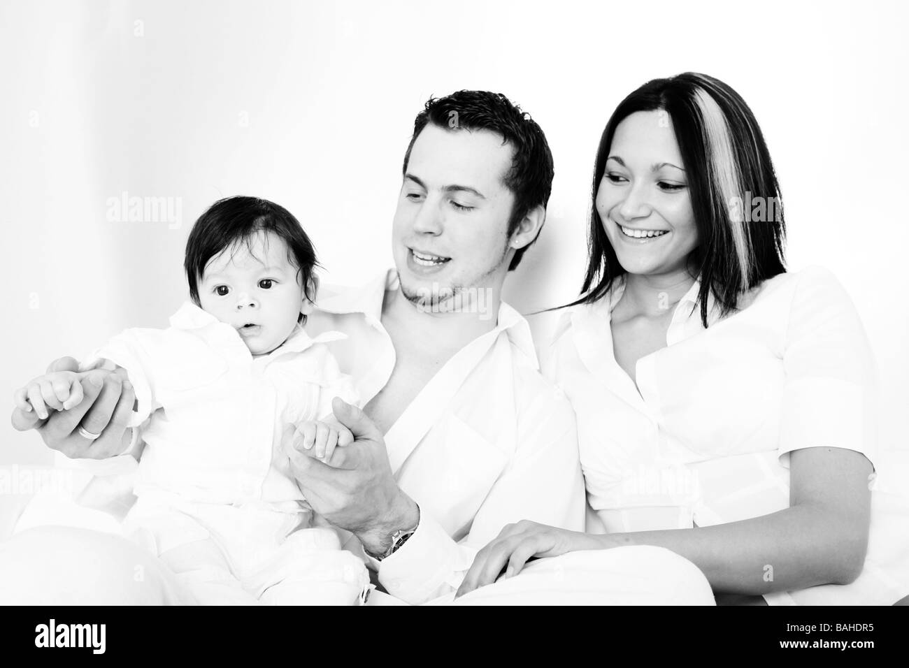 Una giovane famiglia felice con i loro 4 mese vecchio figlio Foto Stock