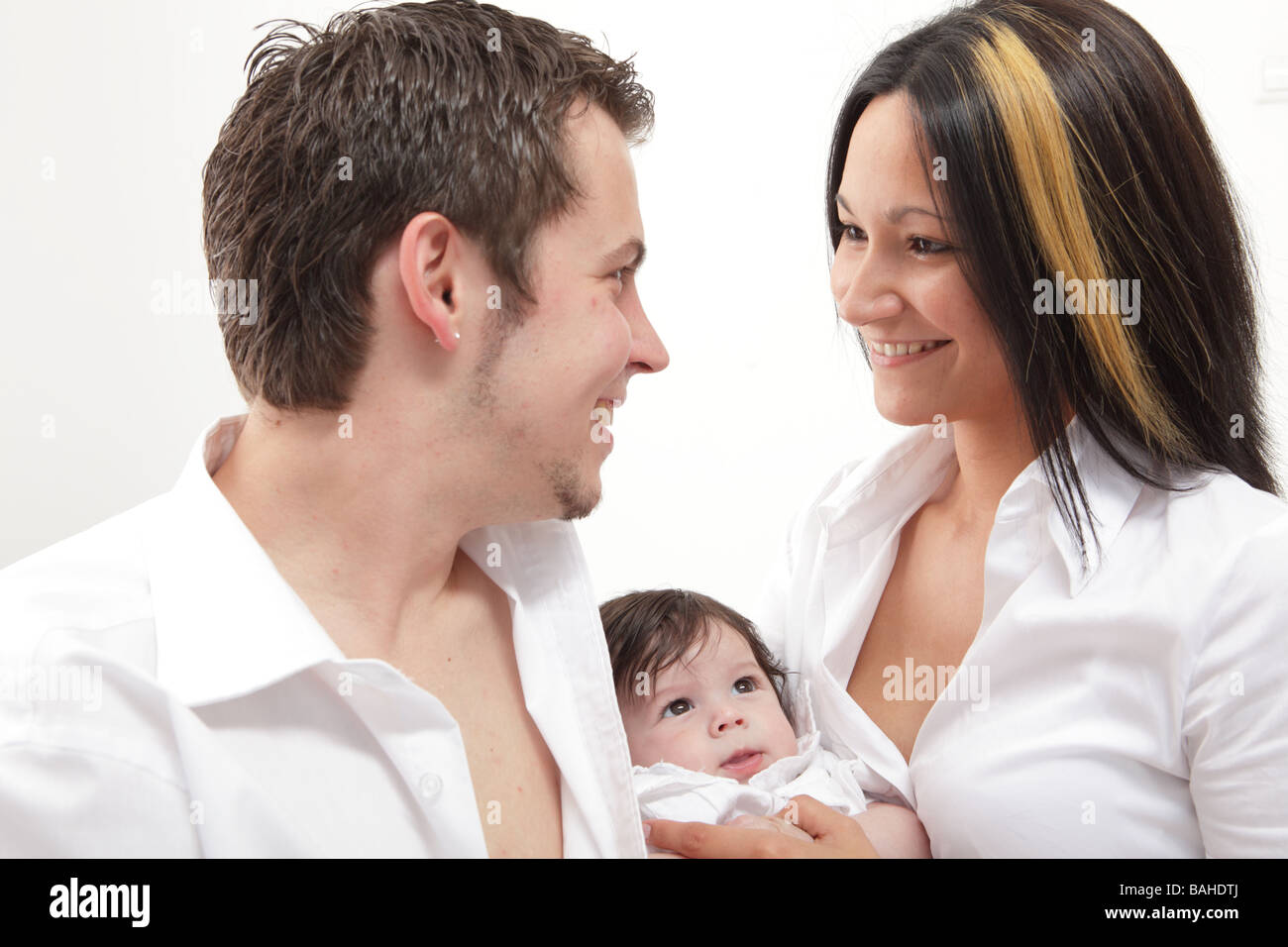 Una giovane famiglia felice con i loro 4 mese vecchio figlio Foto Stock