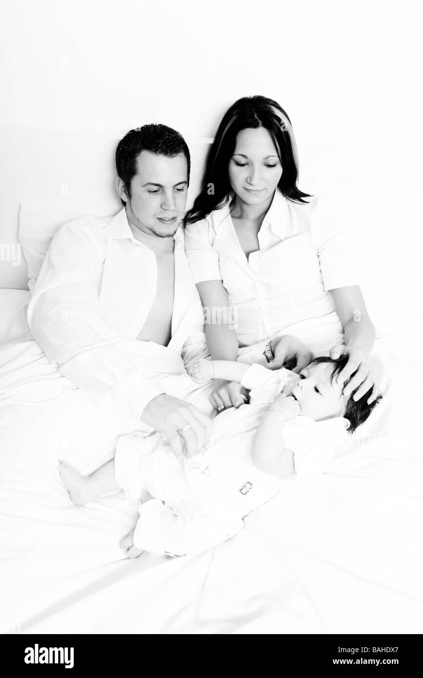 Una giovane famiglia felice con i loro 4 mese vecchio figlio Foto Stock