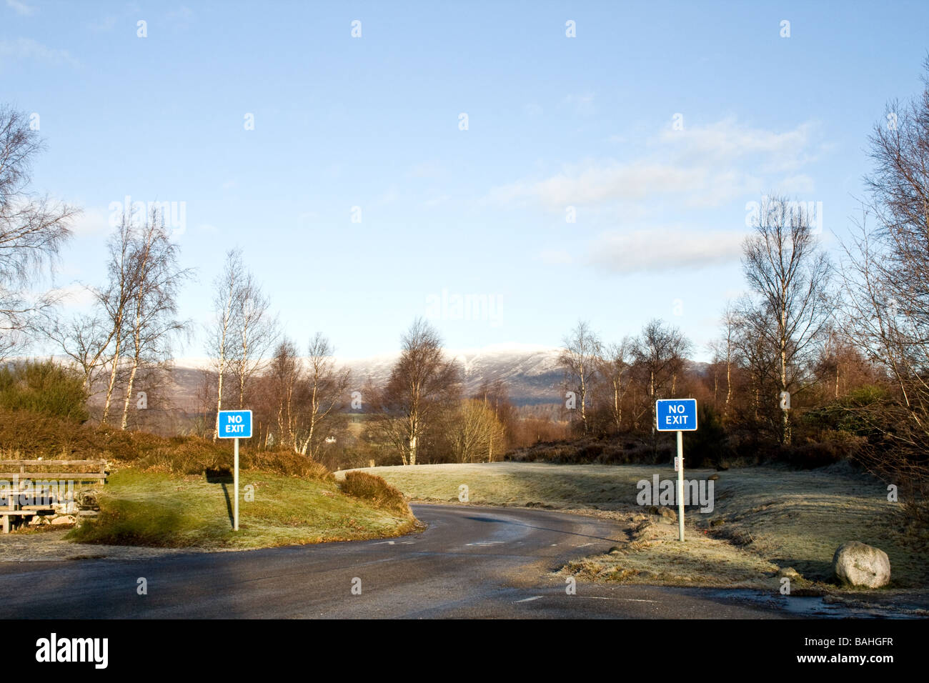 Due blu 'n' uscita segno su una strada ghiacciata di inverno in Scozia Foto Stock