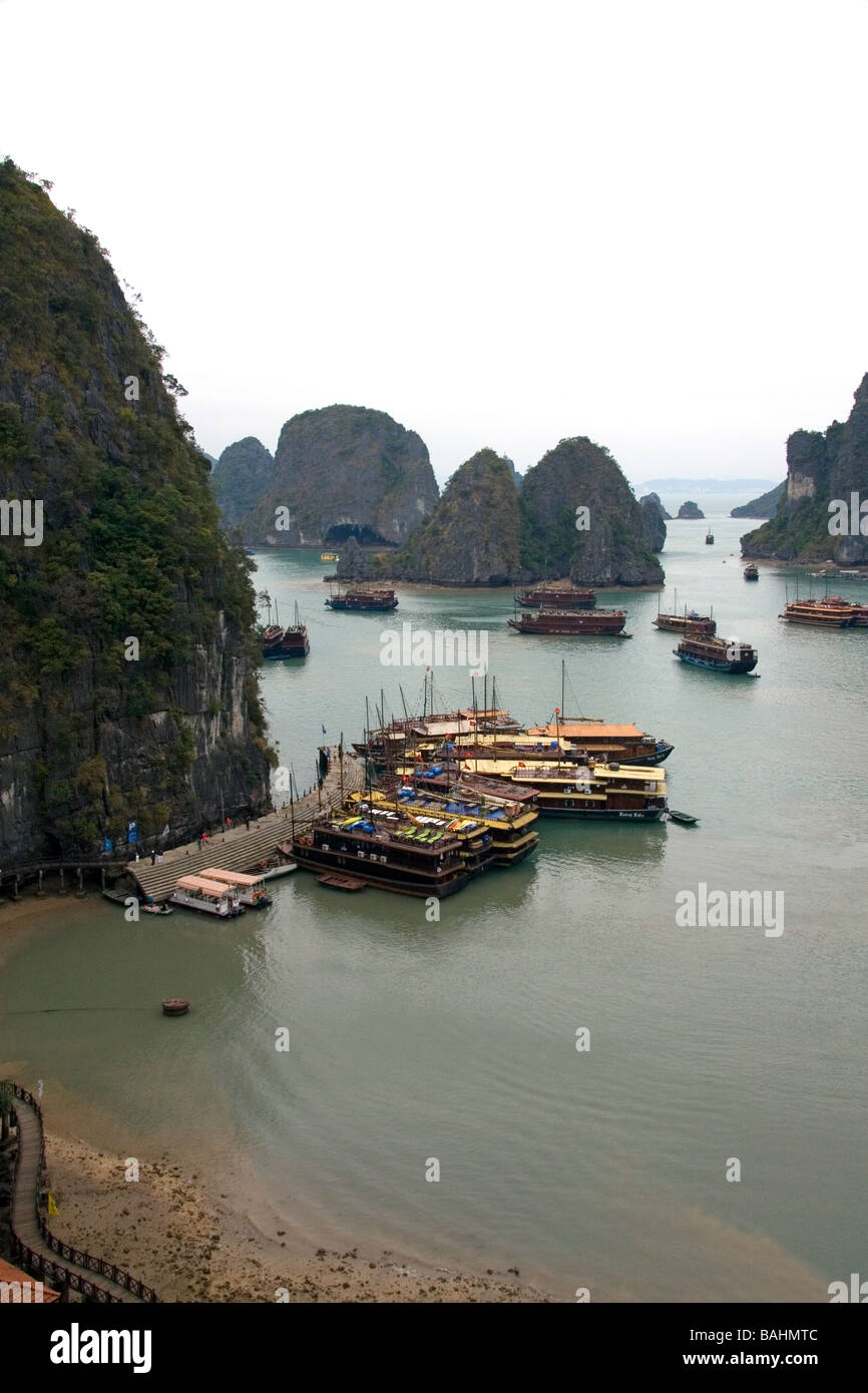 Vedute panoramiche di pietre calcaree carsiche e le imbarcazioni turistiche nella Baia di Ha Long Vietnam Foto Stock