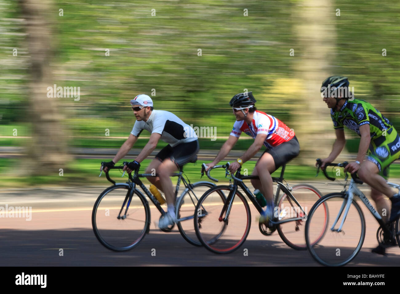 Tre i ciclisti su biciclette da corsa facendo i circuiti di formazione sul cerchio interno Regents Park London sfocatura del movimento Foto Stock