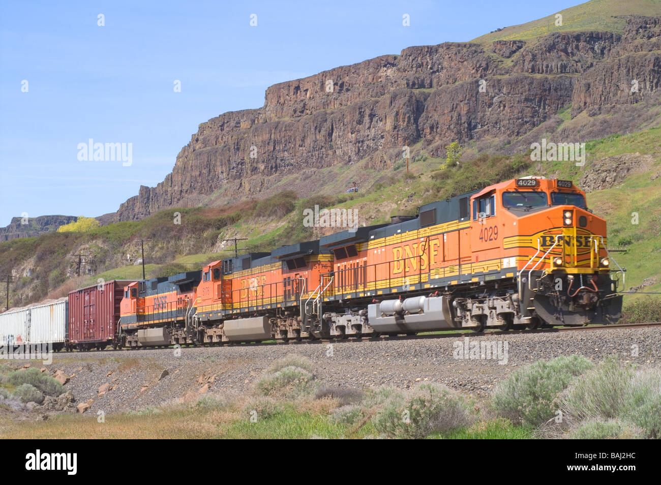 Un BNSF treno passa attraverso il Columbia River Basin con il monte Cofano incombente. Foto Stock