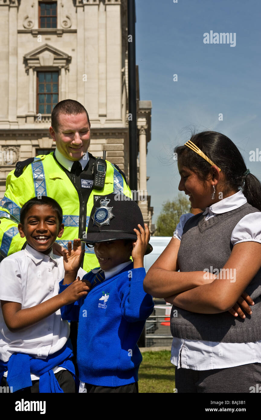 Un Poliziotto metropolitano amichevole che parla con gli scolari asiatici alla protesta tamil a Londra. Foto Stock