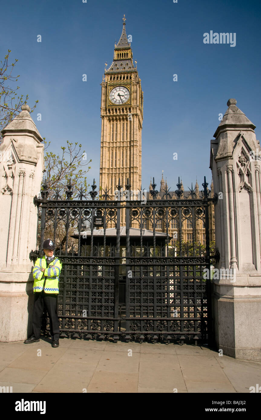 Poliziotto a un gate presso la sede del Parlamento a Londra con il Big Ben in background. Foto Stock