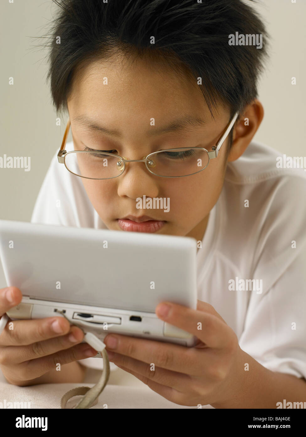 Ragazzo tenendo un portatile di gioco video Foto Stock